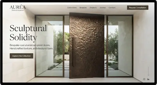 Sculptural cast aluminium pivot door with a hammered sand texture and bronze patina.